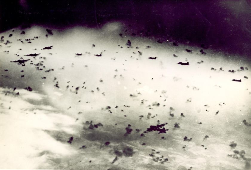 B-17s from the 303rd flying through intense anti-aircraft fire.  Photo by Joseph Sassone with caption: "Flak so thick you could almost taxi around it." 