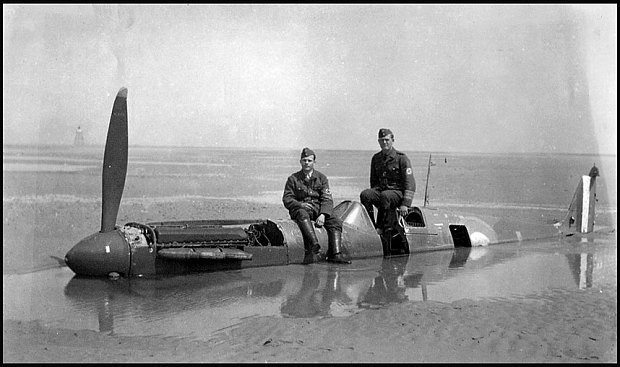 MK1 Spitfire P9374 on the beaches of Dunkirk in Spring 1940 with two German servicemen on her fuselage. © BNPS.